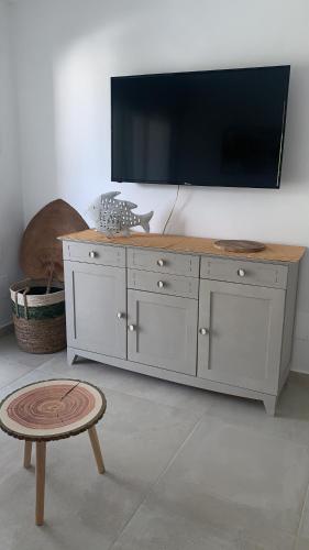 een witte dressoir met een grote televisie aan de muur bij Villa Calma in Cala'n Bosch
