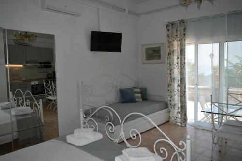 a white bedroom with a bed and a living room at Estate Dafnopanagia Luxury Apartment Ourania in Kariá