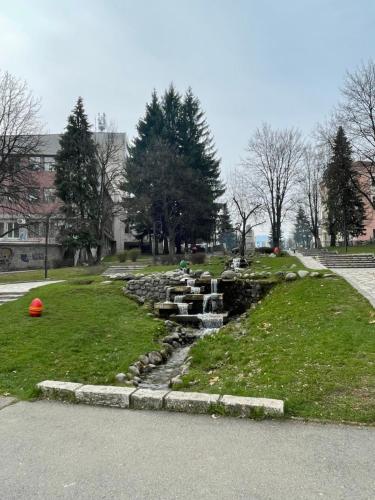 a stream of water in a park with a waterfall at Pirin Dream View Apartments in Razlog