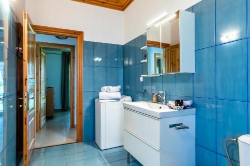 a blue bathroom with a sink and a mirror at Aegean View Villa in Skopelos Town