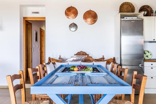 a kitchen with a blue table and chairs at Aegean View Villa - Sea View Family Sanctuary in Skopelos Town