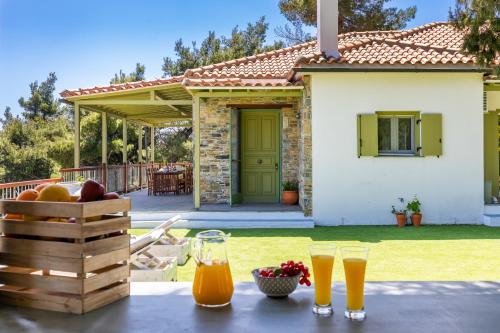 a table with two glasses of orange juice on a patio at Aegean View Villa - Sea View Family Sanctuary in Skopelos Town