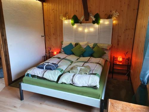 a bedroom with a bed with green pillows and a window at Gîte de la Motte in Tavannes