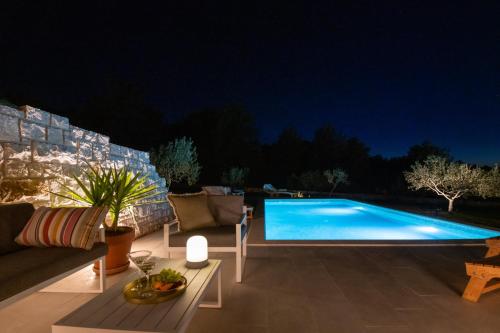 een zwembad in een achtertuin 's nachts bij Villa Mista in Sutivan