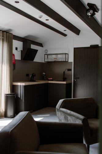 a living room with a couch and a kitchen at De la Rue Vakantiesuites in Sleeuwijk