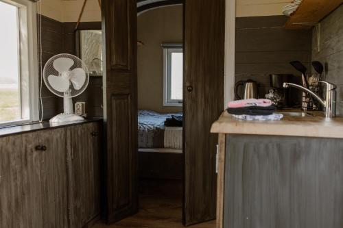 a kitchen with a fan on a counter and a bedroom at De la Rue Pipowagens in Sleeuwijk