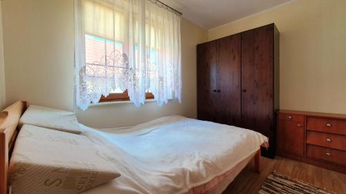 a small bedroom with a bed and a window at Dom letniskowy Narie in Morąg