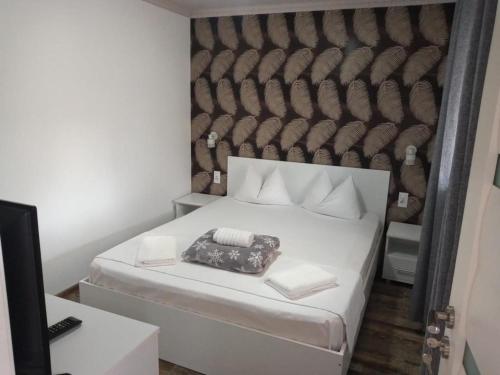sypialnia z białym łóżkiem z zagłówkiem w obiekcie CasaRiana 3 w mieście Eforie Sud