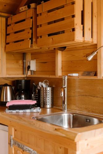 a kitchen with a sink in a wooden kitchen at De la Rue Pipowagens in Sleeuwijk