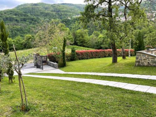 a park with a pathway and flowers and trees at Il paradiso delle beccacce in Popiglio