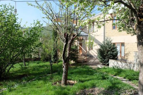 a tree in a yard next to a building at Dil Hill by Sam in Dilijan