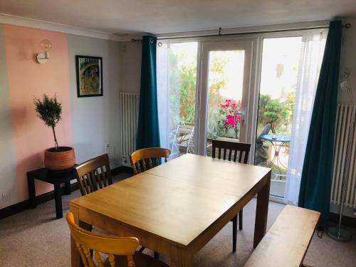 uma sala de jantar com uma mesa e cadeiras e uma janela em Cosy house, 3 bedrooms, private parking, wifi, patio em Norwich