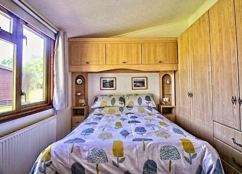 a bedroom with a bed with a comforter on it at Dot's Place 1 in Carnforth