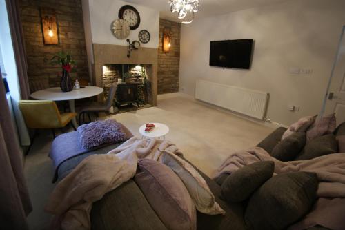 a living room with a couch and a table and a tv at Bank View next to the Fleece Countryside Inn in Barkisland