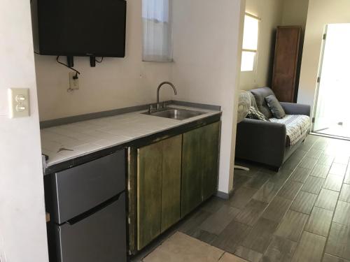 a kitchen with a sink and a couch in a room at Casa Edka in Ensenada