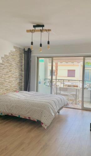 une chambre avec un lit et un mur de briques dans l'établissement Charmant studio juan les pins: 30 mètres de la mer, à Juan-les-Pins