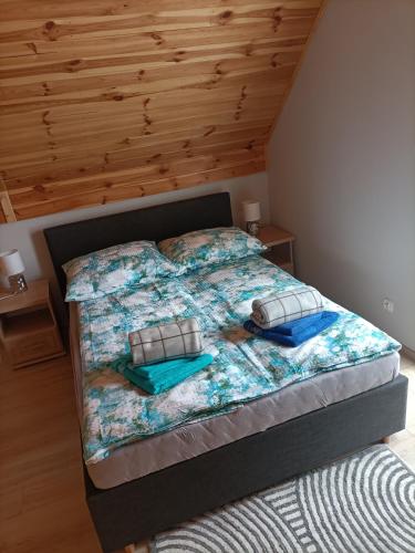 a bed with two pillows on it in a bedroom at Zielona Ostoja in Ryn