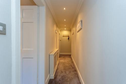 a hallway with a white door and a stairwell at Beautiful Hideout in Center of Edinburgh in Edinburgh