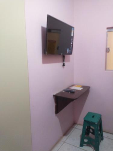 a room with a desk and a tv on a wall at Guaraná da Cláudia in Santarém