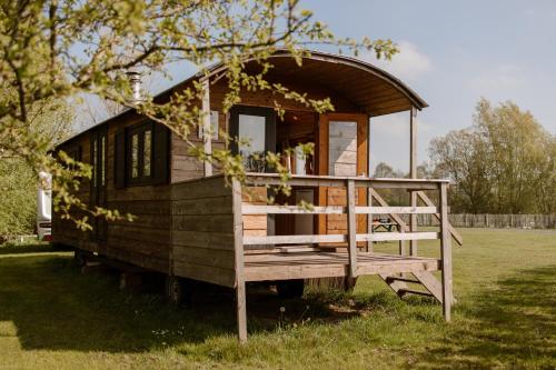 a tiny house is sitting in a field at De la Rue Pipowagens in Sleeuwijk