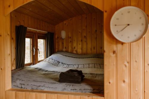 a bedroom with a clock on the wall and a bed at De la Rue Pipowagens in Sleeuwijk