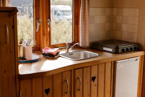 a kitchen counter with a sink and a window at De la Rue Pipowagens in Sleeuwijk