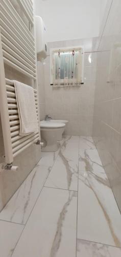 a white bathroom with a toilet and a sink at Agriturismo La Collina Verde in Levanto