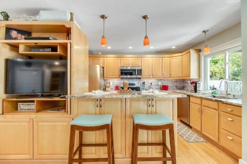 a kitchen with wooden cabinets and a kitchen island with stools at Almost There in Bradenton