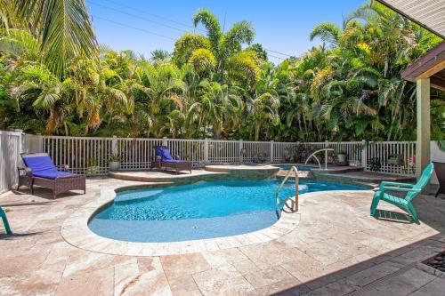 a swimming pool with two chairs and a fence at Almost There in Bradenton