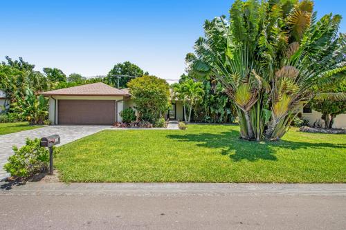 a house with a yard with a palm tree at Almost There in Bradenton