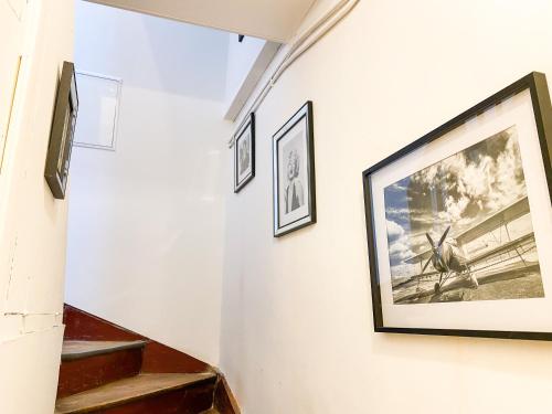 un couloir avec des photos sur le mur et des escaliers dans l'établissement **NEW** Le Nid Douillet au cœur de Guingamp, à Guingamp