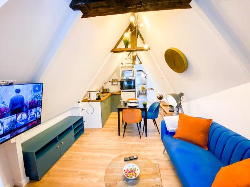 a living room with a blue couch and a tv at **NEW** Le Nid Douillet au cœur de Guingamp in Guingamp