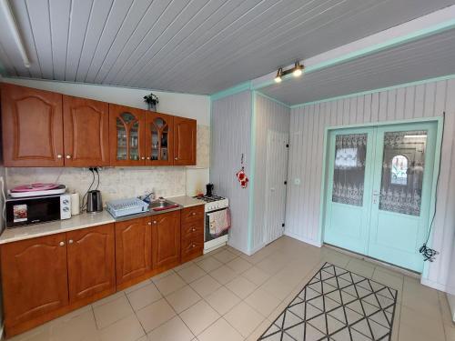 a kitchen with wooden cabinets and a microwave at Stéghouse Kis-Duna in Dömsöd