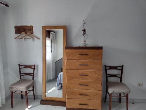 a bedroom with a dresser with a mirror and two chairs at Apartamento de 3 Habitaciones y un baño SIN cocina en San Vicente de O Grove in San Vicente de O Grove