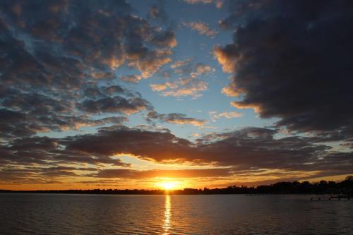 a sunset over a body of water at Toukley Waterfront House in Toukley