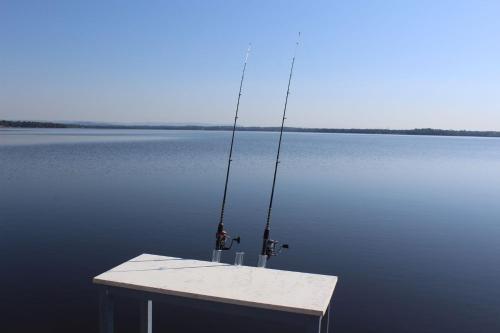 a table with two fishing rods on top of the water at Toukley Waterfront House in Toukley