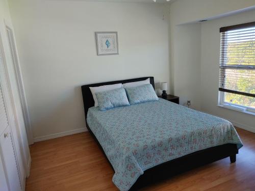 a bedroom with a bed and a window at Melbourne Beach Florida Townhouse ocean front 1.2 acre property in Melbourne Beach