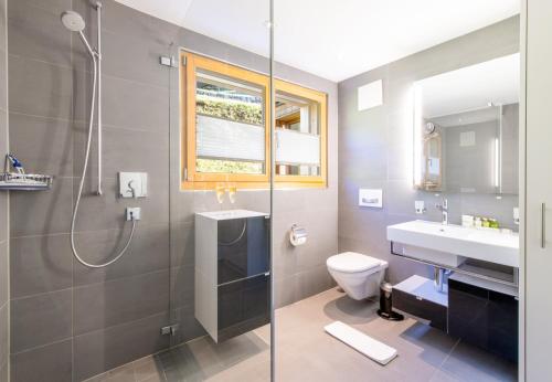 een badkamer met douche, wastafel en toilet bij Chalet Monchsbuffel in Wengen