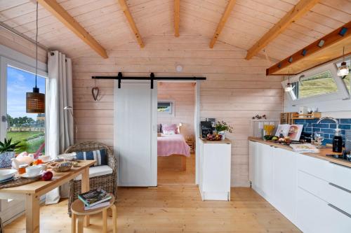 a kitchen and living room with wooden walls at Kaitipu - Papamoa Hills Holiday Cabin in Upper Papamoa