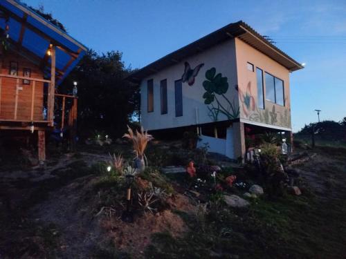 a house with a painting on the side of it at Cabañas el Olimpo in Aquitania