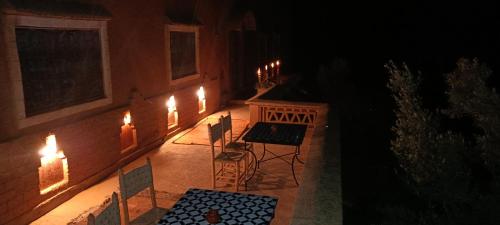 a patio at night with chairs and lights at Dar Mezyana Dades in Aït Idaïr