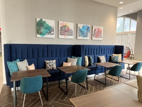 a dining room with tables and chairs and paintings on the wall at Home2 Suites By Hilton St Louis Downtown in Saint Louis
