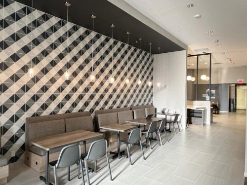 um restaurante com mesas e cadeiras contra uma parede xadrez em Home2 Suites By Hilton St Louis Downtown em Saint Louis