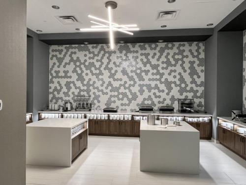 a kitchen with white counters and a patterned wall at Home2 Suites By Hilton St Louis Downtown in Saint Louis