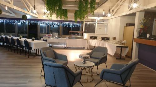 a restaurant with white tables and chairs and a bar at The Select Inn Gosford in Gosford