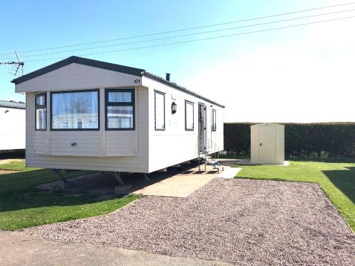 锡勒斯Hylton Park Silloth Caravan Holiday Homes的沙砾堆上的小房子