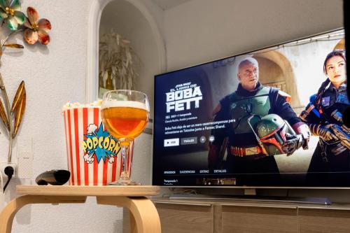 a television screen with a glass of beer on a table at Little House in Center in Almería