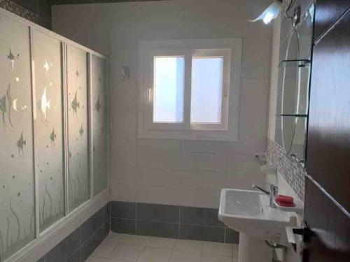 uma casa de banho com um lavatório e uma janela em North coast Sedra Resort Chalet قريه سيدرا الساحل الشمالي علي البحر شاليه ثلاث غرف em Alexandria