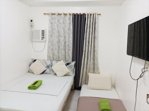 ein Zimmer mit 2 Betten und einem grünen Telefon darauf in der Unterkunft Bolinao Transient House B in Balingasay
