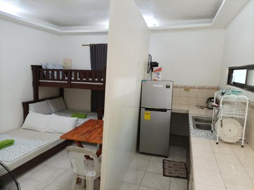 eine Küche mit einem Kühlschrank und einem Tisch im Zimmer in der Unterkunft Bolinao Transient House B in Balingasay